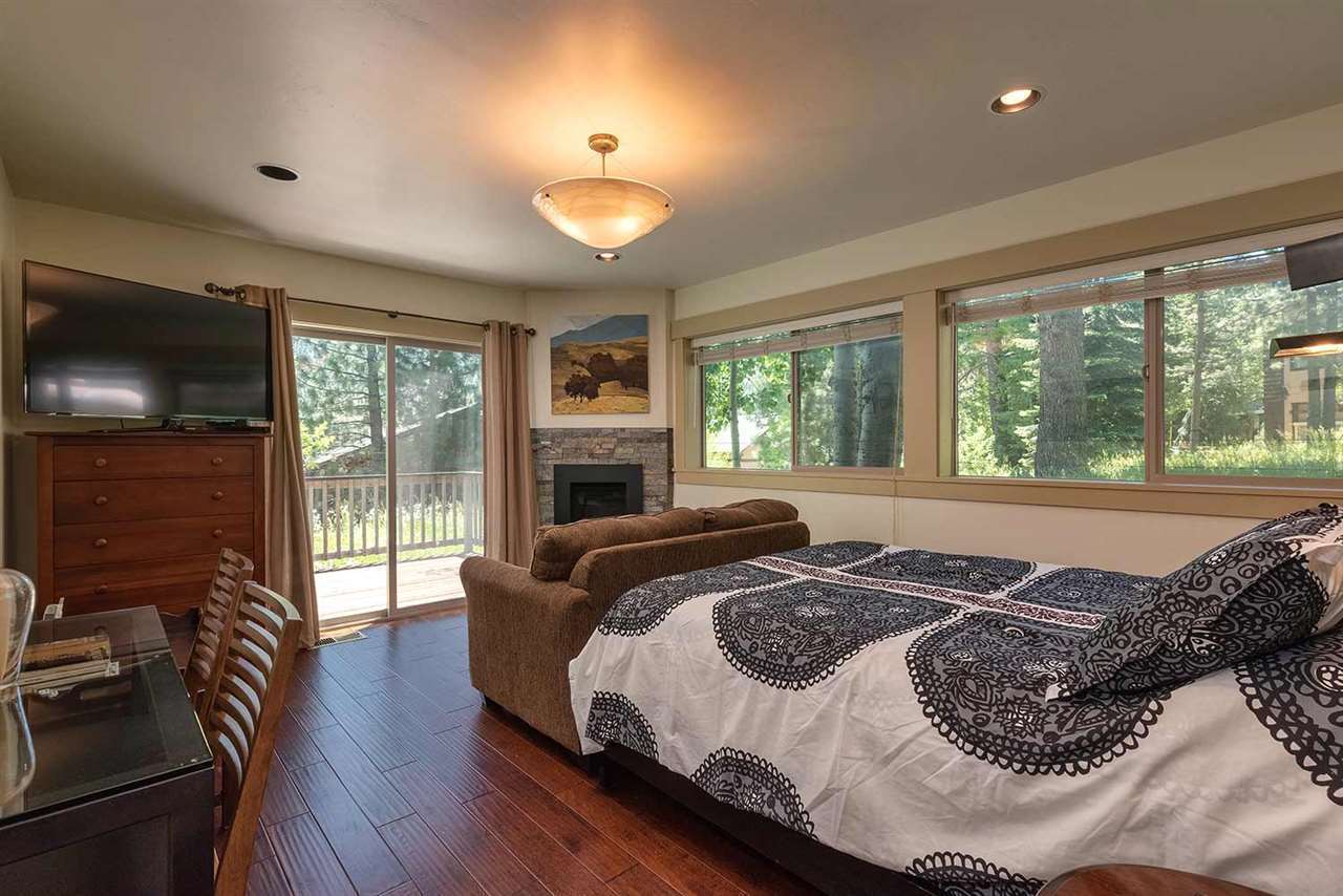Studio bedroom with queen bed, gas fireplace, and forest views at Palisades Tahoe Studio in Olympic Valley
